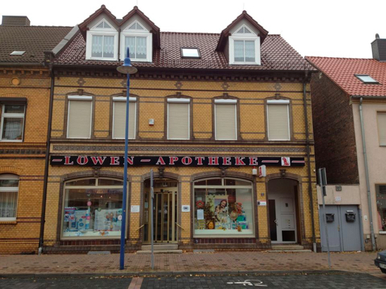 Fassade der Löwen-Apotheke Bitterfeld mit dem roten Schriftzug